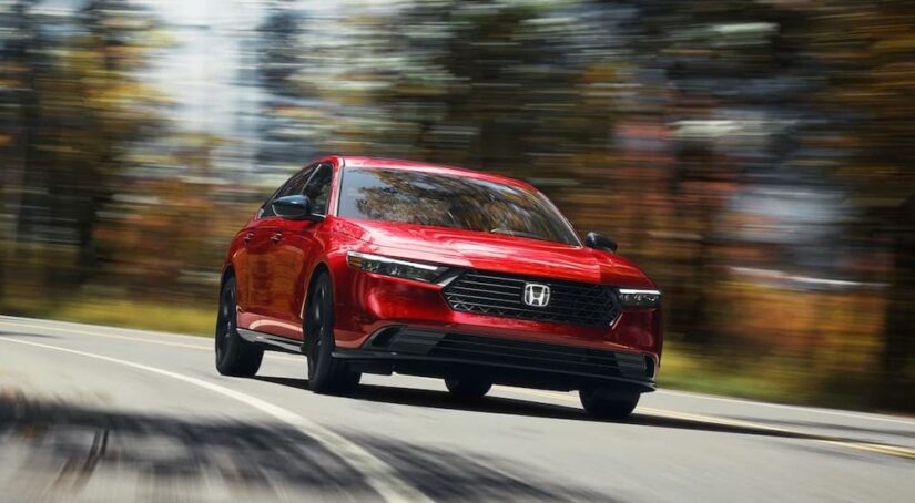A red 2023 Honda Accord Sport-L is shown driving on a highway.