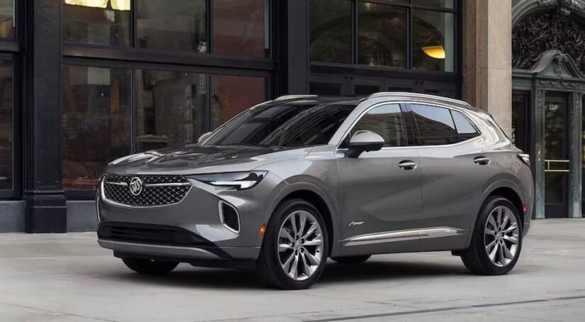 A silver 2023 Buick Envision is shown parked near a building.