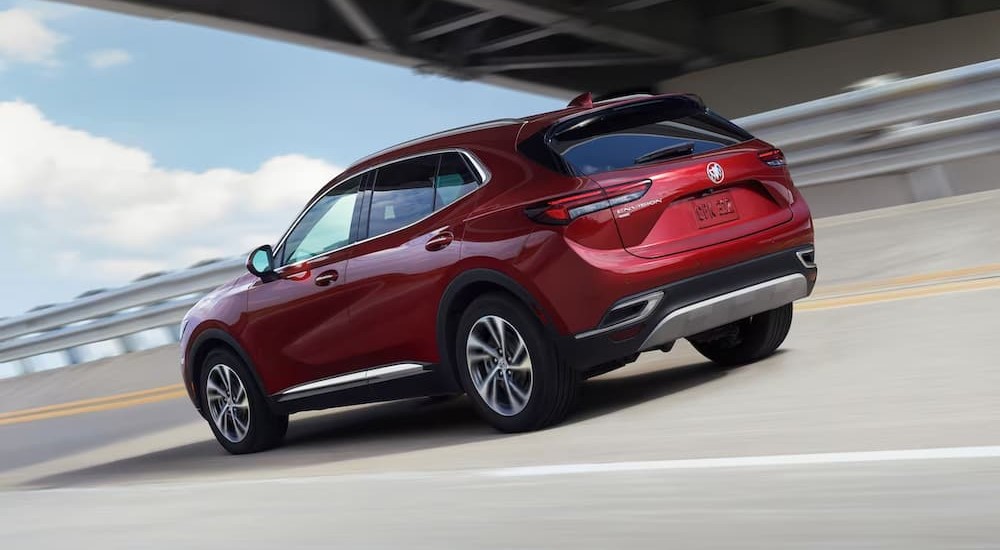 A red 2023 Buick Envision is shown driving on a highway.