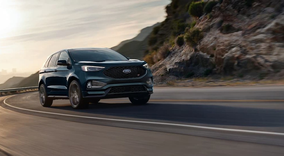 A green 2023 Ford Edge ST is shown driving on a highway.