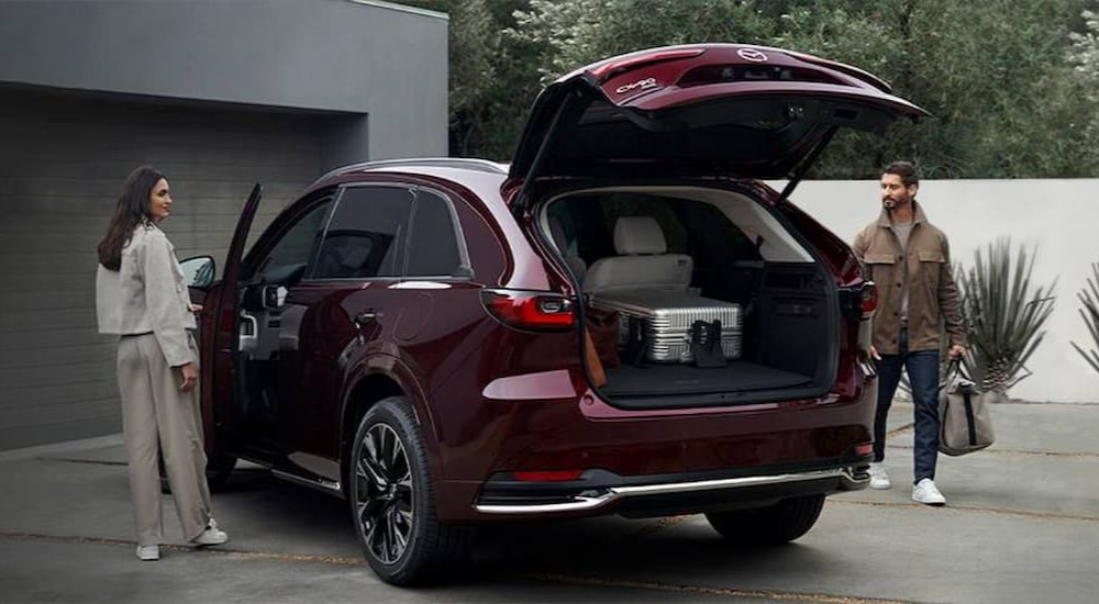 A burgundy 2024 Mazda CX-90 is shown parked on a driveway.