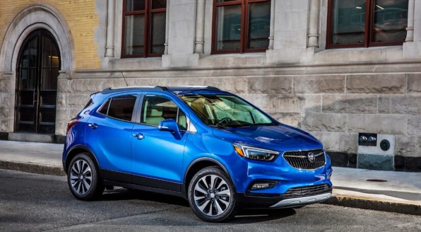 A blue 2019 Buick Encore for sale is shown parked near a building.