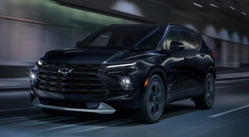 A black 2023 Chevy Blazer for sale is shown driving in a tunnel.