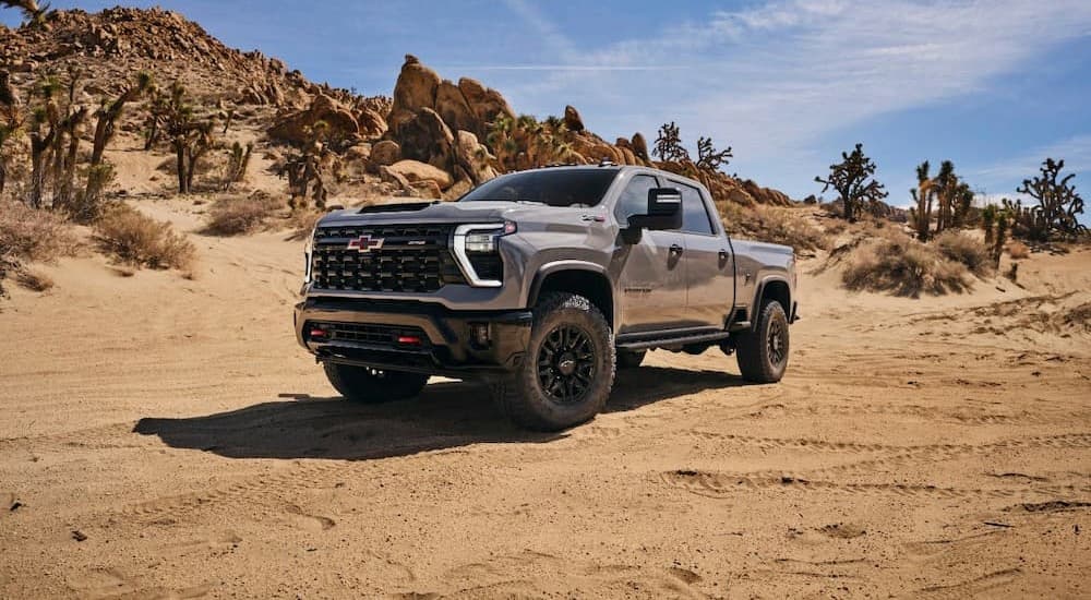 A gray 2024 Chevy Silverado 1500 ZR2 is shown parked on sand.