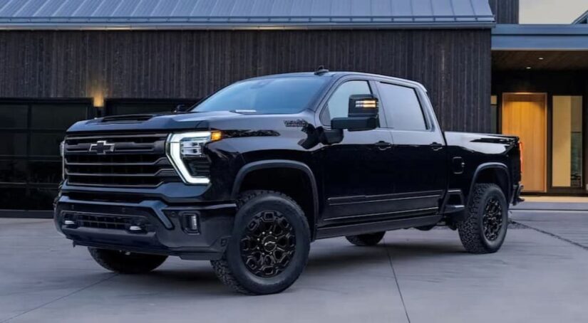 A popular Chevy Silverado for sale, a black 2023 Chevy Silverado 1500 High Country Midnight edition, is shown parked on a driveway.