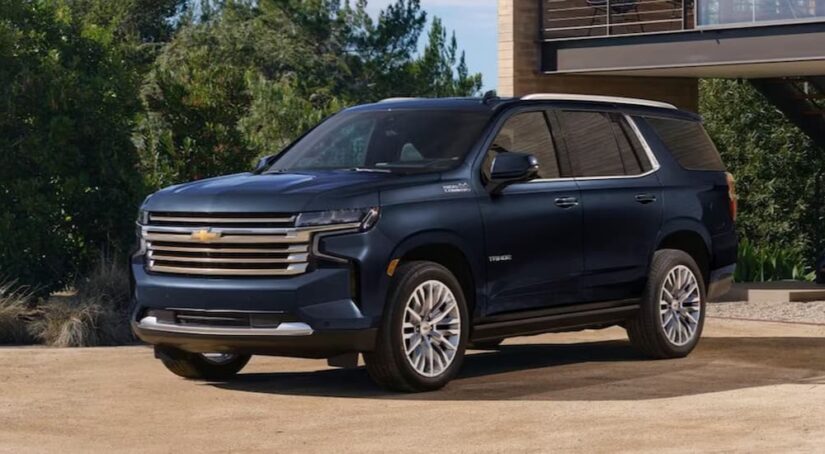 A blue 2023 Chevy Tahoe High Country for sale is shown parked on a driveway.