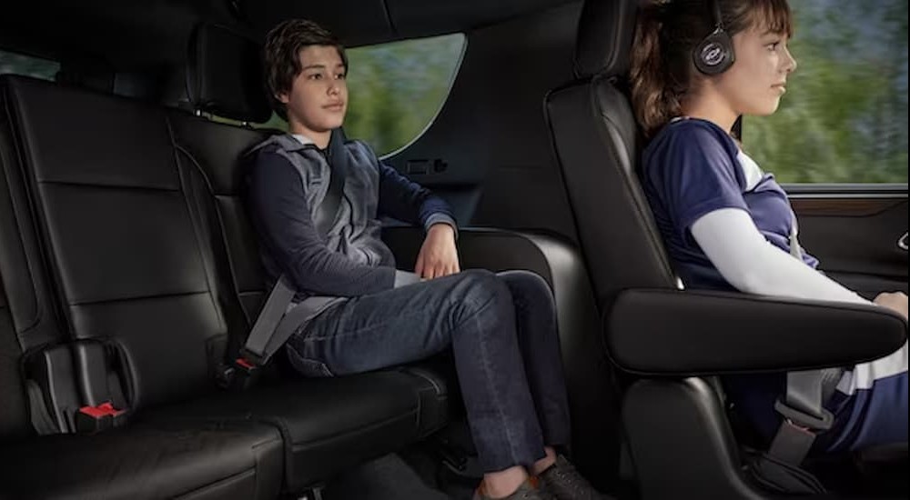 Two children are shown seated inside of a 2023 Chevy Tahoe.