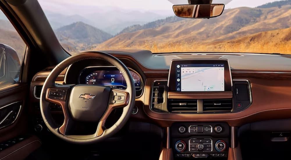 The tan interior and dash of a 2023 Chevy Tahoe is shown.