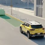A yellow and white 2024 Chevy Trailblazer is shown with simulated sensor lines on a city street.