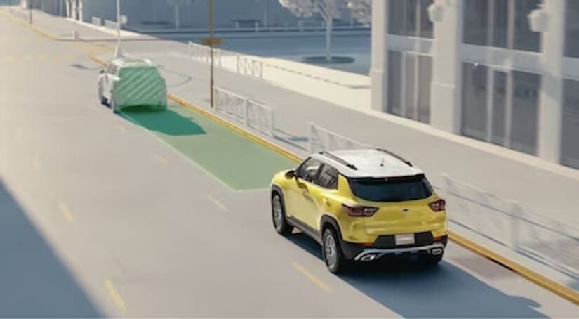 A yellow and white 2024 Chevy Trailblazer is shown with simulated sensor lines on a city street.