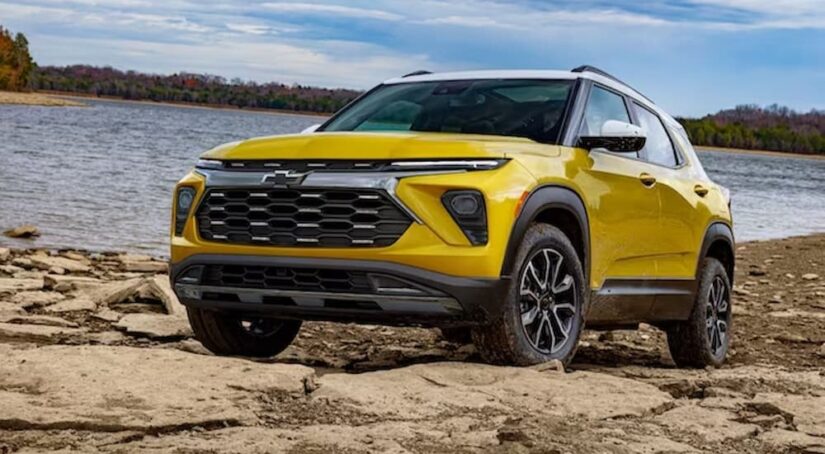 A yellow 2024 Chevy Trailblazer Activ for sale is shown parked near a lake.