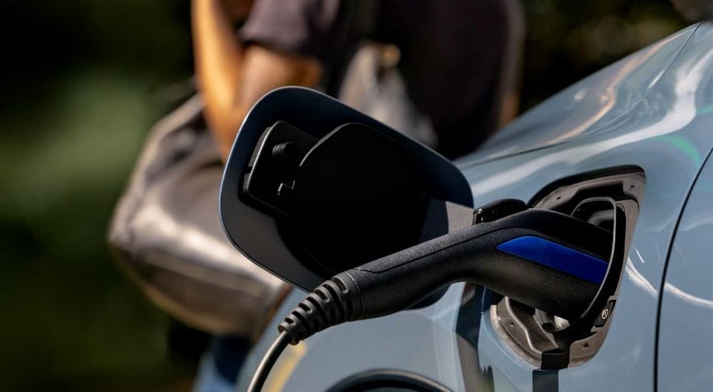 A charge plug is shown being used on a blue 2023 Ford Escape.