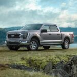 A silver 2021 Ford F-150 for sale is shown parked off-road.