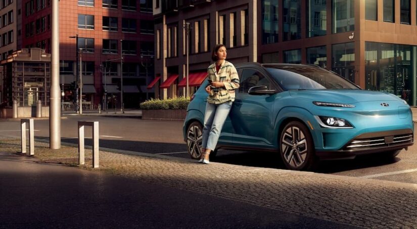 A blue 2023 Hyundai Kona Electric for sale is shown parked on a street.