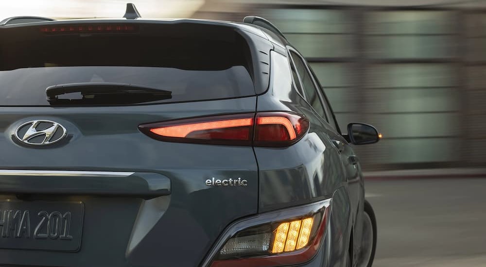The rear end and tail light of a gray 2023 Hyundai Kona Electric is shown.