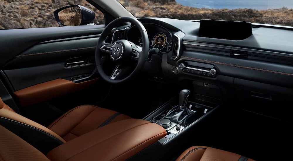 The black and brown interior and dash of a 2023 Mazda CX-50 is shown.