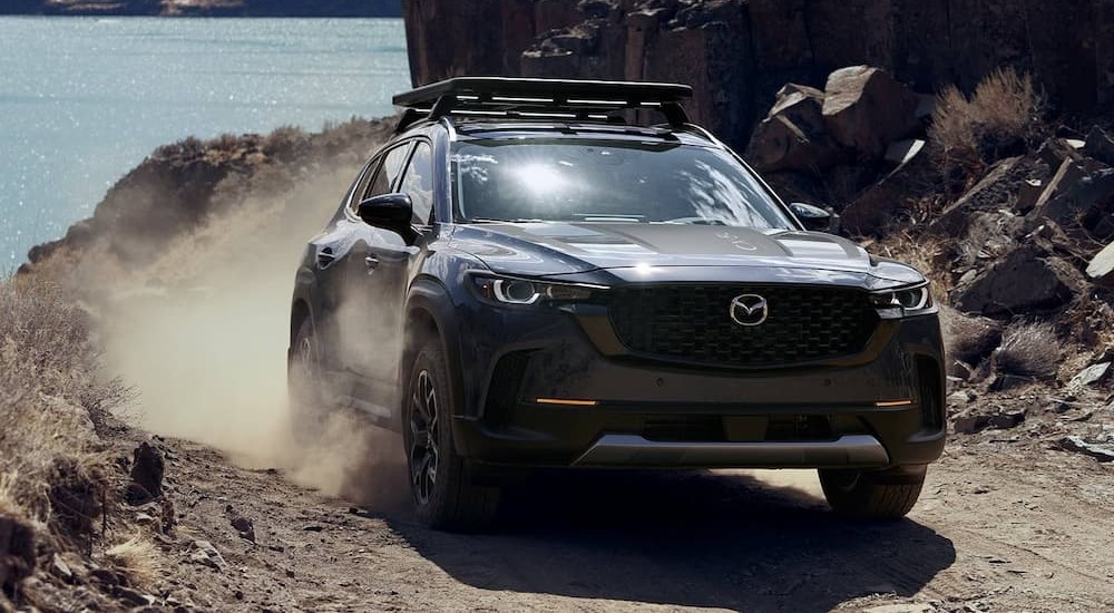 A blue 2023 Mazda CX-50 is shown off-roading.