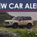 A tan 2024 Lexus GX is shown from the under a new car alert banner.