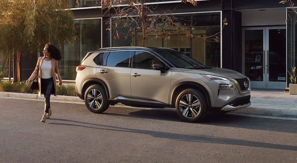 A silver 2023 Nissan Rogue Platinum AWD is shown parked on a street.