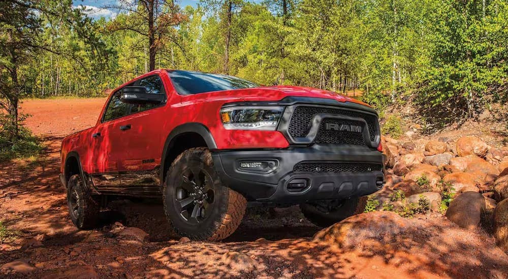 A red 2023 Ram 1500 is shown off-roading.