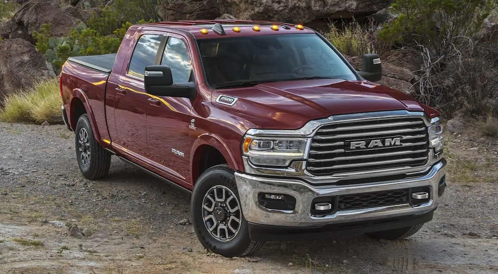 A burgundy 2023 Ram 2500 is shown parked on a dirt road.