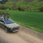 A green 2024 Subaru Outback for sale is shown on a dirt trail.