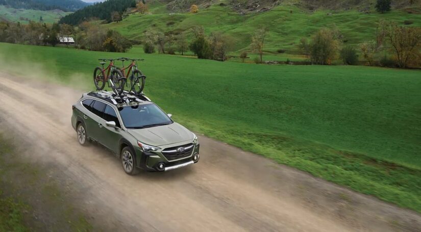 A green 2024 Subaru Outback for sale is shown on a dirt trail.