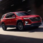 A red 2023 Chevy Traverse is shown driving from the side after winning a 2023 Chevy Traverse vs 2023 Dodge Durango comparison.