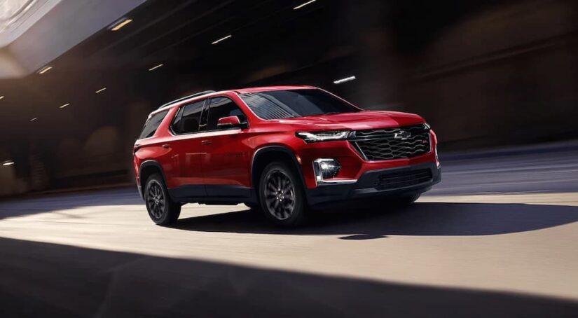 A red 2023 Chevy Traverse is shown driving from the side after winning a 2023 Chevy Traverse vs 2023 Dodge Durango comparison.