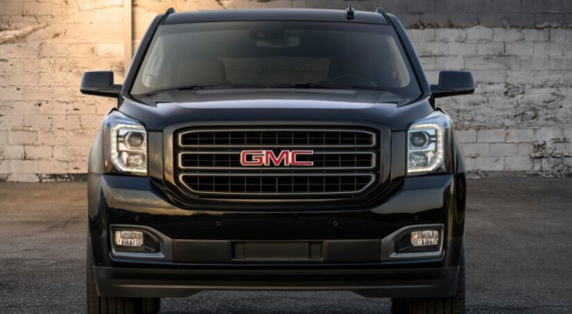 A black 2019 GMC Yukon Graphite Edition is shown parked near a white wall after visiting a used GMC dealer.