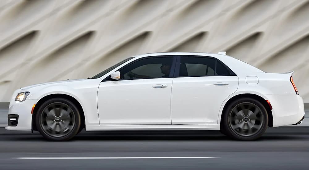 A white 2019 Chrysler 300 is shown driving on a highway.