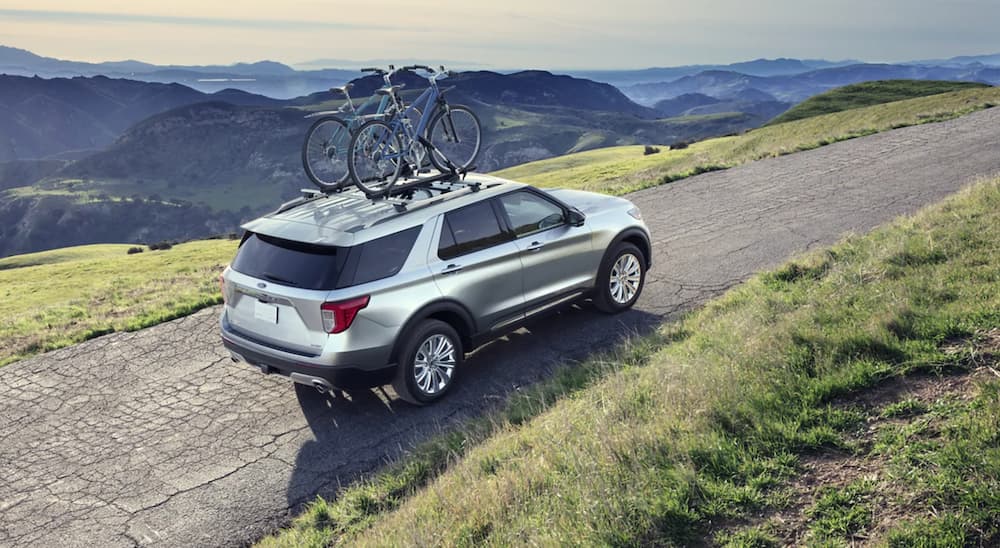 A silver 2021 Ford Explorer is shown from the rear at an angle during a 2023 Ford Explorer vs 2023 Chevy Traverse comparison.