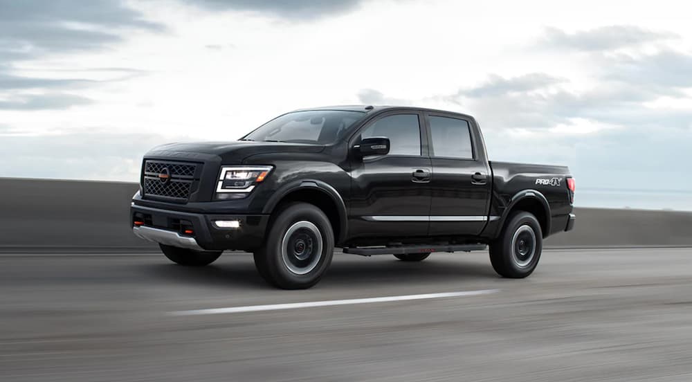 A black 2023 Nissan Titan Pro-4x is shown from the side on the highway.