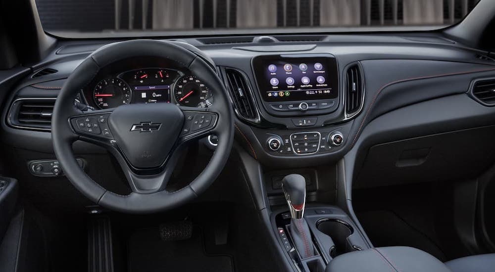 The black interior of a 2023 Chevy Equinox is shown from the driver's seat.
