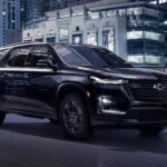 A black 2023 Chevy Traverse Midnight Edition is shown driving on a bridge after winning a 2023 Chevy Traverse vs 2023 Toyota Highlander comparison.