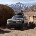 A grey 2023 Ford Bronco Sport is shown on a trail kicking up dust after winning a 2023 Ford Bronco Sport vs 2023 Kia Seltos showdown.