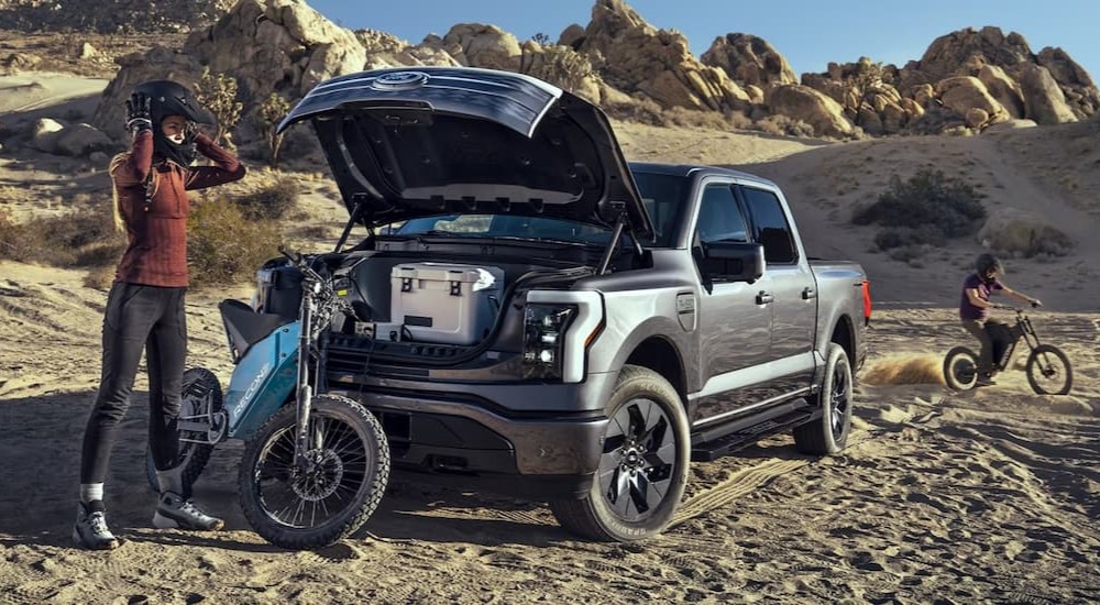 A gray 2023 Ford F-150 Lightning is shown parked off-road.