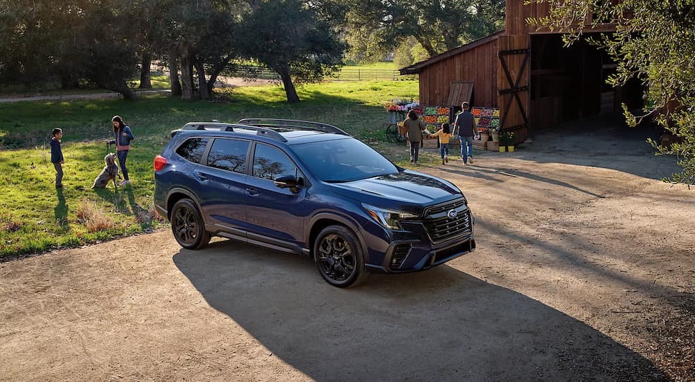 A blue 2023 Subaru Ascent is shown parked near a barn.