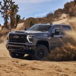 A gray 2024 Chevy Silverado 2500 HD ZR2 is shown off-roading.