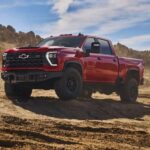 A red 2024 Chevy Silverado 2500 HD ZR2 Bison is shown parked off-road after winning a 2024 Chevy Silverado 2500 HD vs 2023 Chevy Silverado 2500 HD comparison.