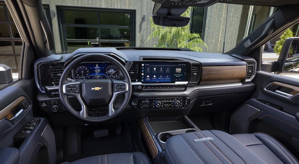 The black and wood paneled interior and dash of a 2024 Chevy Silverado 2500 HD High Country is shown.