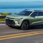 A green 2024 Chevy Trax is shown driving near the ocean after winning a 2024 Chevy Trax vs 2023 Chevy Trax comparison.