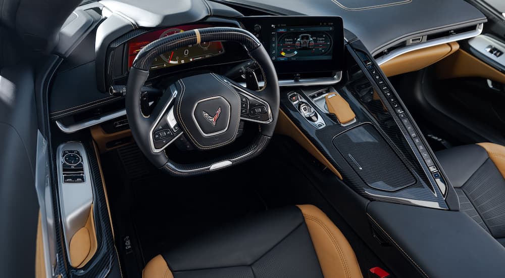 The black and tan interior of a 2024 Chevy Corvette E-Ray is shown from above the driver's seat.