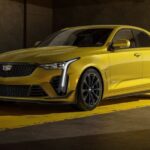 A yellow 2023 Cadillac CT4-V Blackwing is shown parked in a garage.