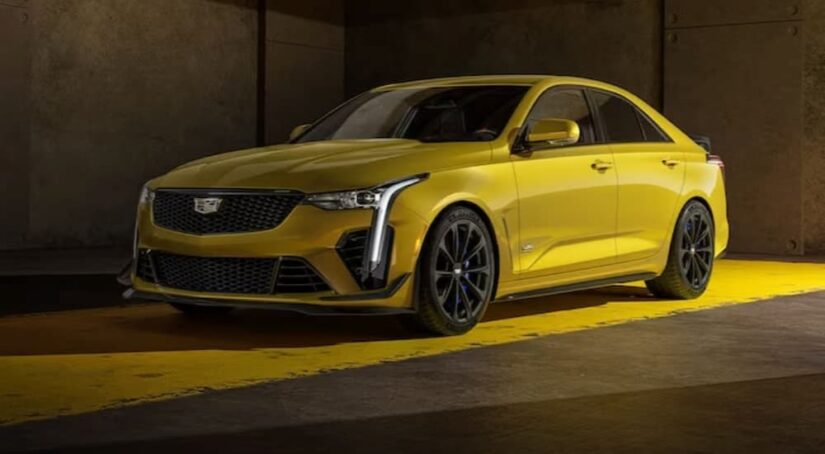 A yellow 2023 Cadillac CT4-V Blackwing is shown parked in a garage.