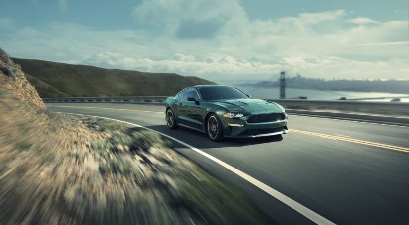 A green 2020 Ford Mustang BULLITT is shown rounding a corner after looking at local car sales.