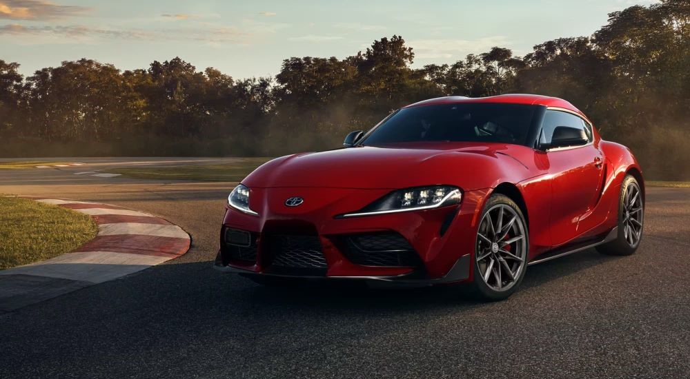 A red 2021 Toyota GR Supra is shown at a racetrack.