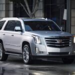 A popular Certified Pre-Owned Cadillac Escalade for sale, a silver 2018 Cadillac Escalade is shown parked near a store.