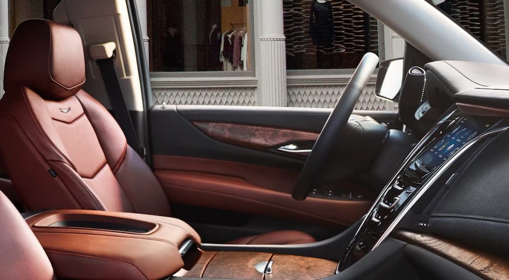 The black and brown interior and dash of a 2020 Cadillac Escalade is shown.