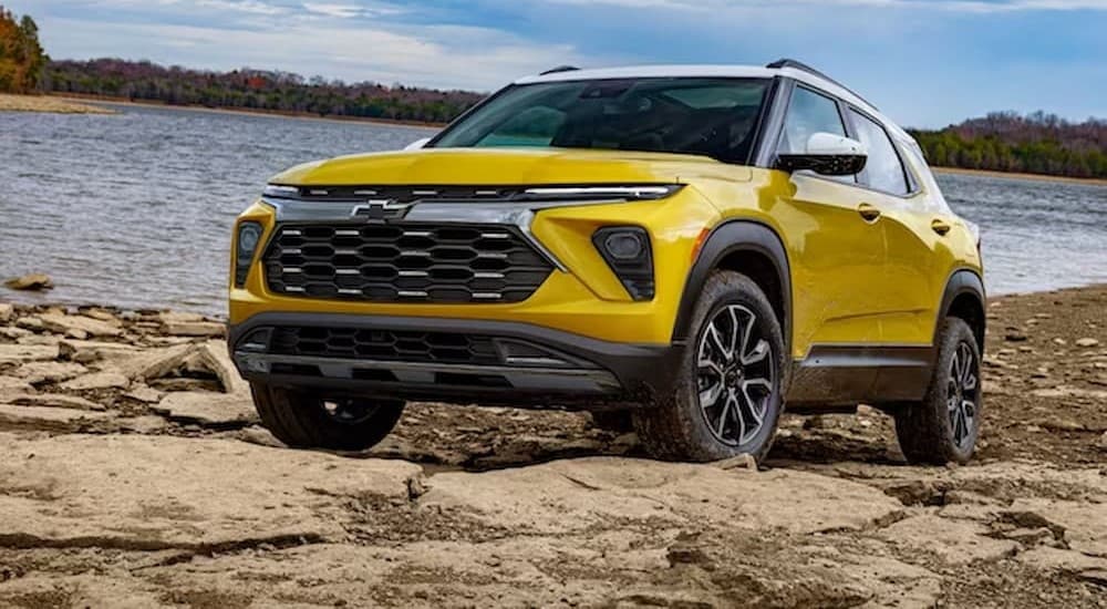A yellow 2024 Chevy Trailblazer for sale is shown parked off-road.